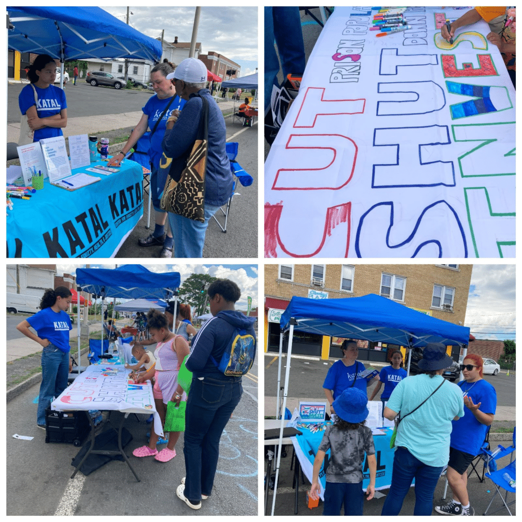 A four-photo collage showing a community outreach table set up outdoors under a blue canopy. Volunteers wearing Katal T-shirts talk with neighbors, share information, and help children color a large sign that reads “Shut Down Prison Pipeline.” The scenes show people of different ages engaging in conversation, art activities, and community organizing at a neighborhood event.